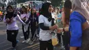 Sejumlah relawan membagikan bunga mawar ke warga saat berlangsungnya kegiatan car free day di kawasan Bundaran HI, Jakarta, Minggu (30/6/2019).  Aksi 1000 bunga mawar itu sebagai bentuk rasa syukur atas kemenangan pasangan Jokowi-Ma'ruf Amin di Pilpres 2019. (Liputan6.com/Immanuel Antonius)