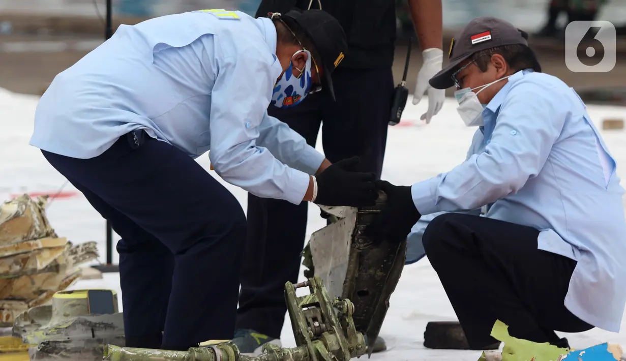 Tim Komite Nasional Keselamatan Transportasi (KNKT) memeriksa serpihan pesawat Sriwijaya Air SJ 182 yang berhasil dtemukan dan dievakuasi tim SAR gabungan di Dermaga JICT, Jakarta, Minggu (10/1/2021). Sriwijaya Air SJ 182 jatuh di perairan Kepulauan Seribu. (Liputan6.com/Helmi Fithriansyah)
