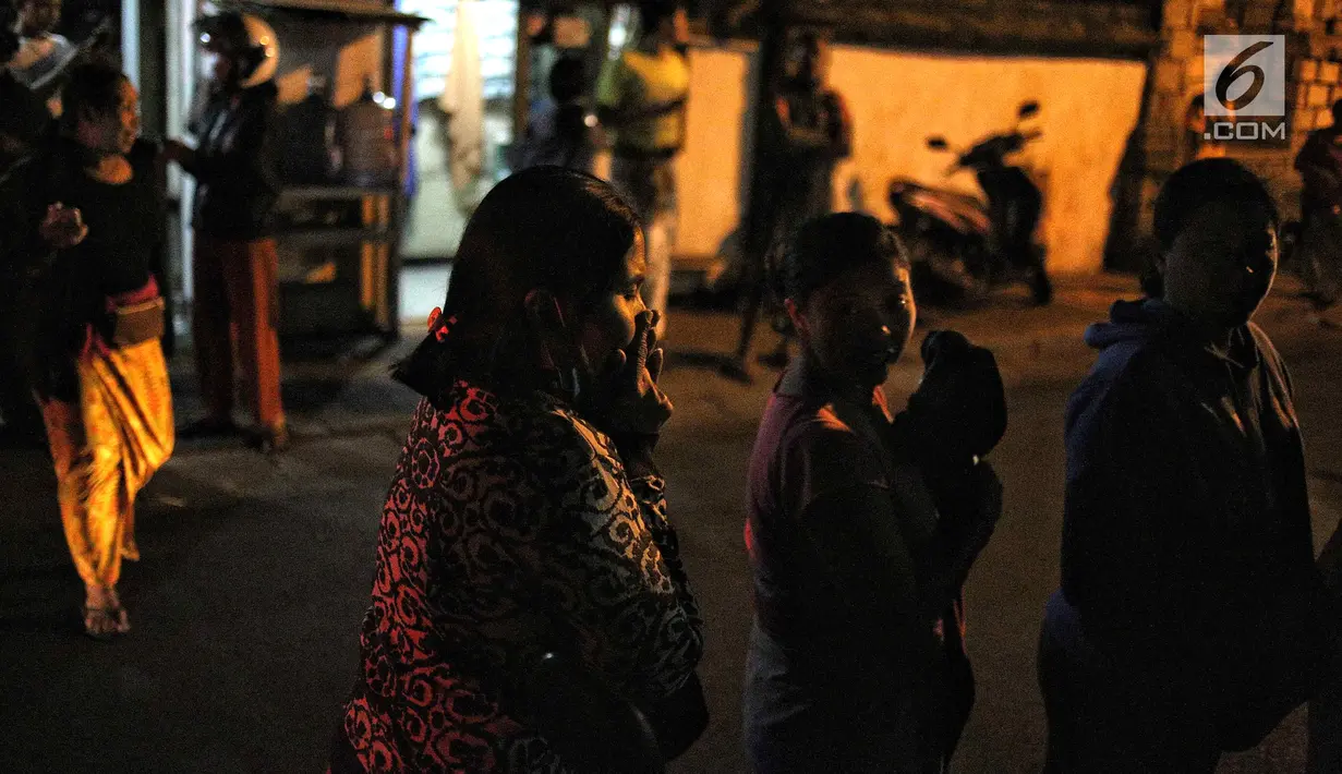 Warga berhamburan keluar rumah saat gempaberkekuatan 7 SR di Lombok dirasakan di kawasan Nusa Dua Bali, Minggu (5/8). Badan Meteorologi, Klimatologi, dan Geofisika (BMKG) menyatakan, gempa berpotensi menimbulkan tsunami. (Liputan6.com/Faizal Fanani)