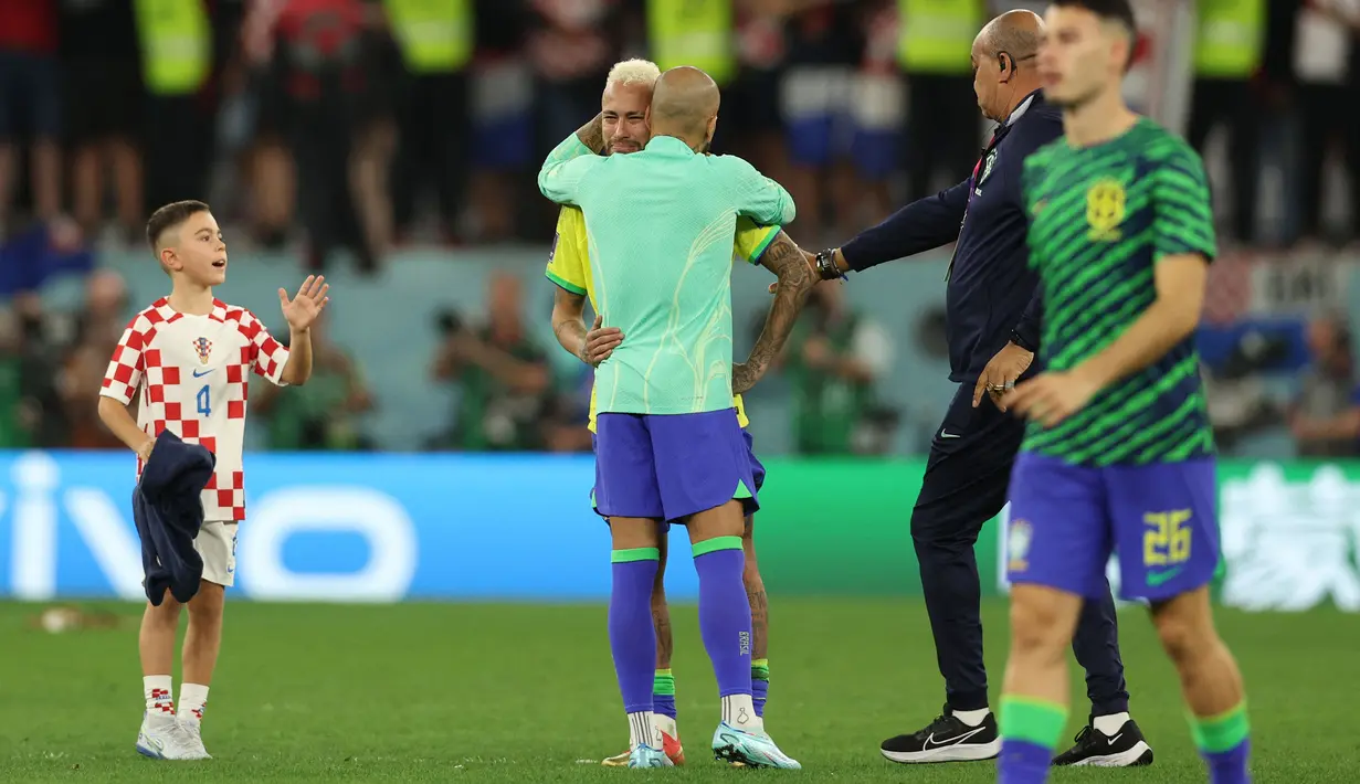 Momen itu berawal dari seorang bocah yang tiba-tiba brelari mendatangi Neymar yang sedang dihibur oleh Dani Alves. Bocah yang diketahui merupakan anak dari Ivan Perisic itu sempat dihentikan official Brasil. (AFP/Adrian Dennis)