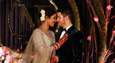 Aktris Bollywood Priyanka Chopra dan musisi AS Nick Jonas berpose saat resepsi pernikahan mereka di New Delhi, India, Selasa (4/12). Keduanya berkali-kali melepas senyum bahagia kepada publik. (AP Photo/Altaf Qadri)