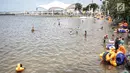 Sejumlah pengunjung bermain air di Beach Pool Ancol, Jakarta, Selasa (25/12). Pasangnya air laut dan cuaca buruk mengakibatkan pantai Ancol sepi pengunjung saat libur Natal 2018. (Liputan6.com/Faizal Fanani)