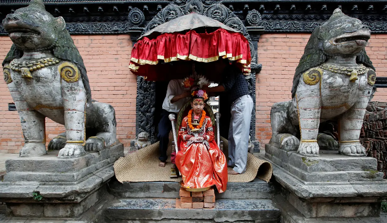 Dewi Hidup, Kumari Unikia Bajracharya saat dipersiapkan untuk mengikuti festival untuk Rato Machhindranath di Lalitpur, Nepal, (10/5). Kumari ini akan kembali normal ketika mereka beranjak dewasa dan mengalami menstruasi. (REUTERS/Navesh Chitrakar)
