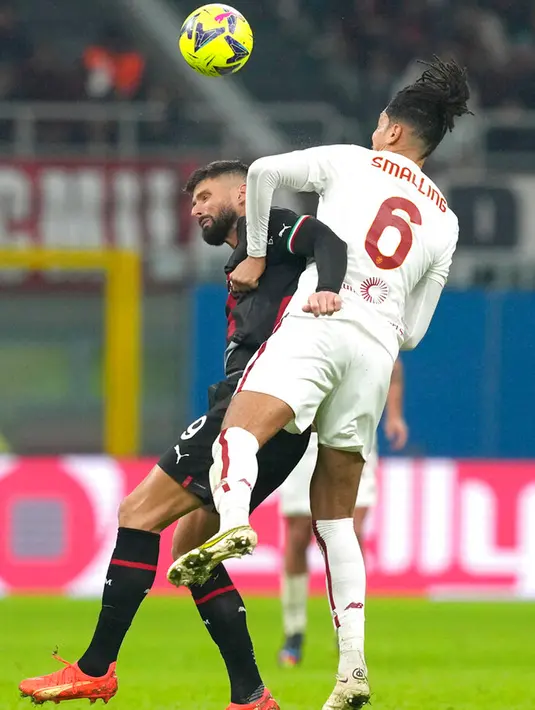 Pemain AC Milan Olivier Giroud (kiri) berebut bola dengan pemain AS Roma Chris Smalling pada pertandingan sepak bola Serie A Liga Italia di Stadion San Siro, Milan, Italia, 8 Januari 2023. Pertandingan berakhir imbang 2-2. (AP Photo/Antonio Calanni)