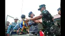 Salah satu anggota TNI AL memberikan pelatihan singkat pada pedangdut Dewi Perssik di Lapangan Tembak Mabesal, Cilangkap, Jakarta, Jumat (27/2/2015). (Liputan6.com/Yoppy Renato)