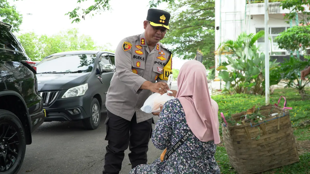 Kapolres Rokan Hulu AKBP Budi Setiyono berbagi makanan gratis kepada masyarakat sebelum dalam kegiatan Jumat berkah.