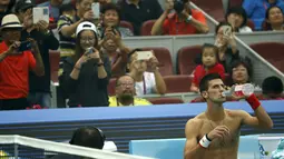Petenis  Novak Djokovic melepas baju saat berhadapan dengan petenis Italia Simone Bolelli di China Open tennis tournament, Beijing, China, Selasa (06/10/2015).  (REUTERS/Kim Kyung-Hoon)