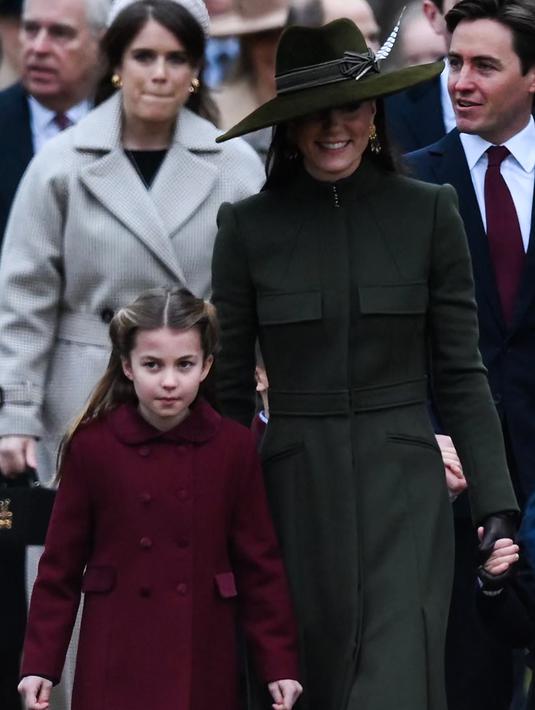 Kate Middleton, Princess of Wales dari Inggris bersama Putri Charlotte tiba untuk kebaktian Natal di Sandringham, Norfolk, Inggris pada 25 Desember 2022. Kate memasangkan mantel tersebut dengan sepatu bot hitam berbahan suede Gianvitto Rossi, lengkap dengan hak chunky. (AFP/Daniel Leal)