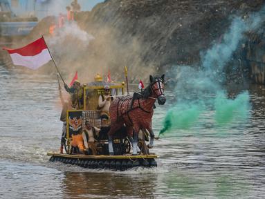 Peserta berparade dengan perahu yang terbuat dari sampah daur ulang mengikuti Festival Perahu Cilung 2025 di kawasan jalan Inspeksi Kali Ciliwung, Pancoran, Jakarta Selatan, Minggu (28/9/2025). (merdeka.com/Arie Basuki)