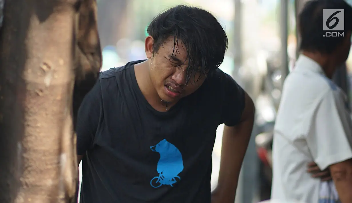 Seorang warga membasuh wajahnya usai mengalami mata perih saat melintas di Jalan KS Tubun, Petamburan, Jakarta Barat, Kamis (23/5/2019). Sisa gas air mata untuk membubarkan massa dalam kericuhan aksi 22 Mei masih terasa dan mengganggu aktvitas pengguna jalan. (Liputan6.com/Immanuel Antonius)