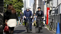 Walikota London Boris Johnson (kiri) bersepeda dengan Walikota Shibuya Ken Hasebe di Tokyo,  Rabu (14/10/2015).   Johnson mengajak pemerintah Tokyo berkerja sama untuk  mendorong Investasi, lapangan pekerjaan dan pertumbuhan ekonomi. (REUTERS/Issei Kato)