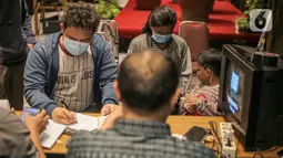 Warga mendaftar untuk mendapatkan alat STB atau Set Top Box yang dibagikan secara gratis di Posko Respon Cepat Penanganan Bantuan STB di Hotel Akmani, Jakarta, Kamis (3/11/2022). Pemerintah memulai migrasi siaran TV analog ke TV digital atau Analog Swicth Off (ASO) pada 2 November 2022 pukul 24.00 WIB yang dilakukan secara bertahap. (Liputan6.com/Faizal Fanani)
