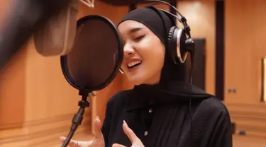 Dalam unggahan foto saat melakukan rekaman lagu, Cita Citata terlihat tampil dalam balutan hijab pasmina berwarna hitam. Penampilan wanita 28 tahun ini pun menjadi sorotan netizen. (Liputan6.com/IG/@cita_citata)