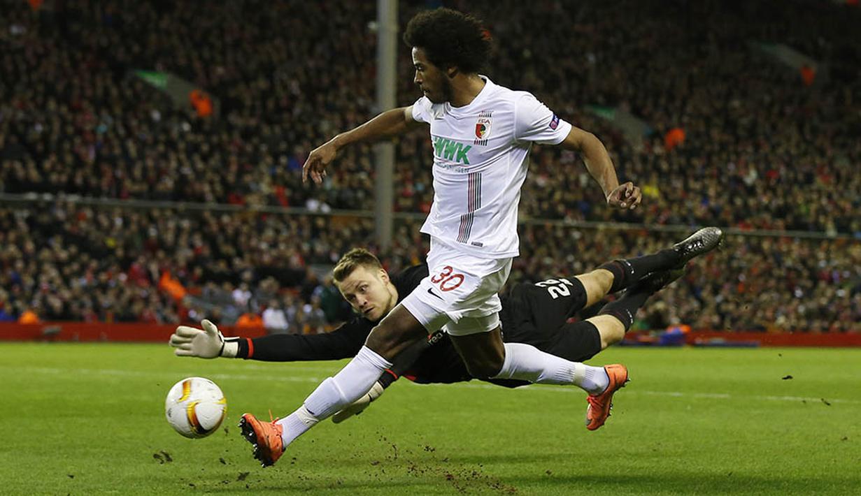 Kiper Liverpool, Simon Mignolet, mengamankan gawangnya dari serangan pemain Augsburg, Caiuby. Augsburg sendiri melakukan dua kali tendangan ke arah gawang dan delapan kali tendangan melebar. (Reuters/Andrew Yates)