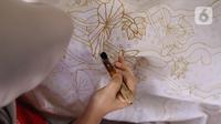 Perajin batik sedang menyelesaikan proses pembuatan batik tulis di Sanggar Batik Kembang Mayang, Larangan, Tangerang, Banten, Minggu (19/7/2020). Rata-rata, lama pembuatan untuk selembar batik tulis adalah sekitar sebulan. (Liputan6.com/Angga Yuniar)