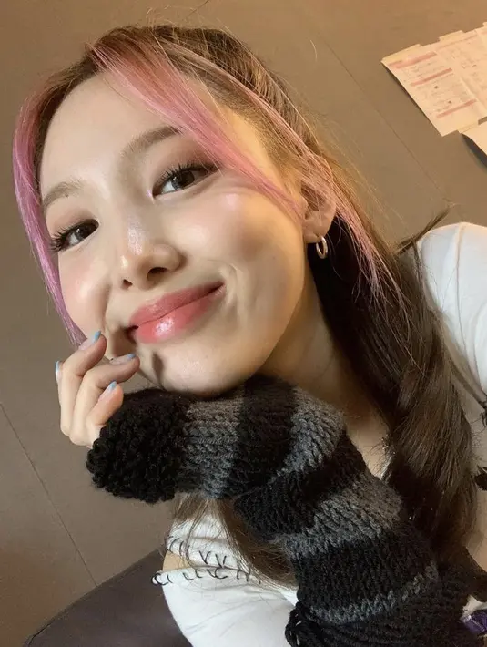 Gaya rambut kuncir setengah juga sepertinya menjadi favorit Nayeon, namun kali ini lebih rapi dengan poni depan yang diwarnai pink. Instagram @twicetagram