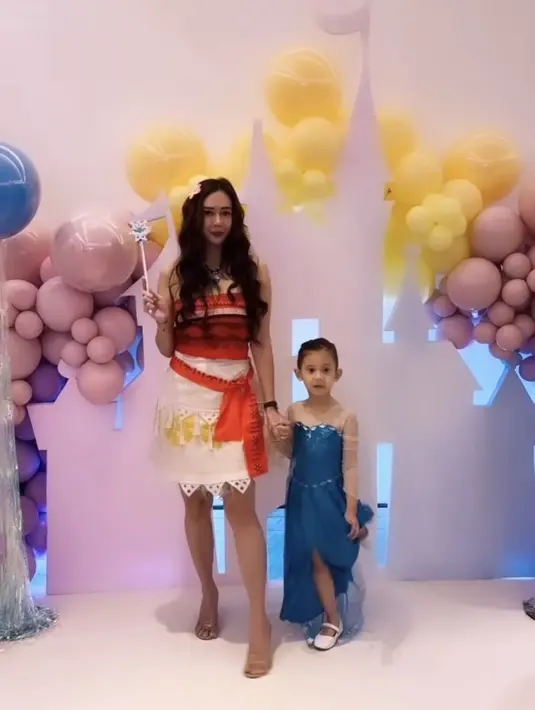 Aura Kasih hadir dengan kostum Moana serba orange, bersama putrinya yang mengenakan dress biru mirip Elsa Frozen. [@aurakasih]