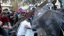 Warga  membawa balok kayu saat bentrok dengan polisi di Quito, Ekuador, Kamis (13/8/2015). Puluhan warga dan aktivis protes rencana Presiden Ekuador, Rafael Correa yang akan menaikan pajak dan pengulangan pemilu. (REUTERS/Guillermo Granja)
