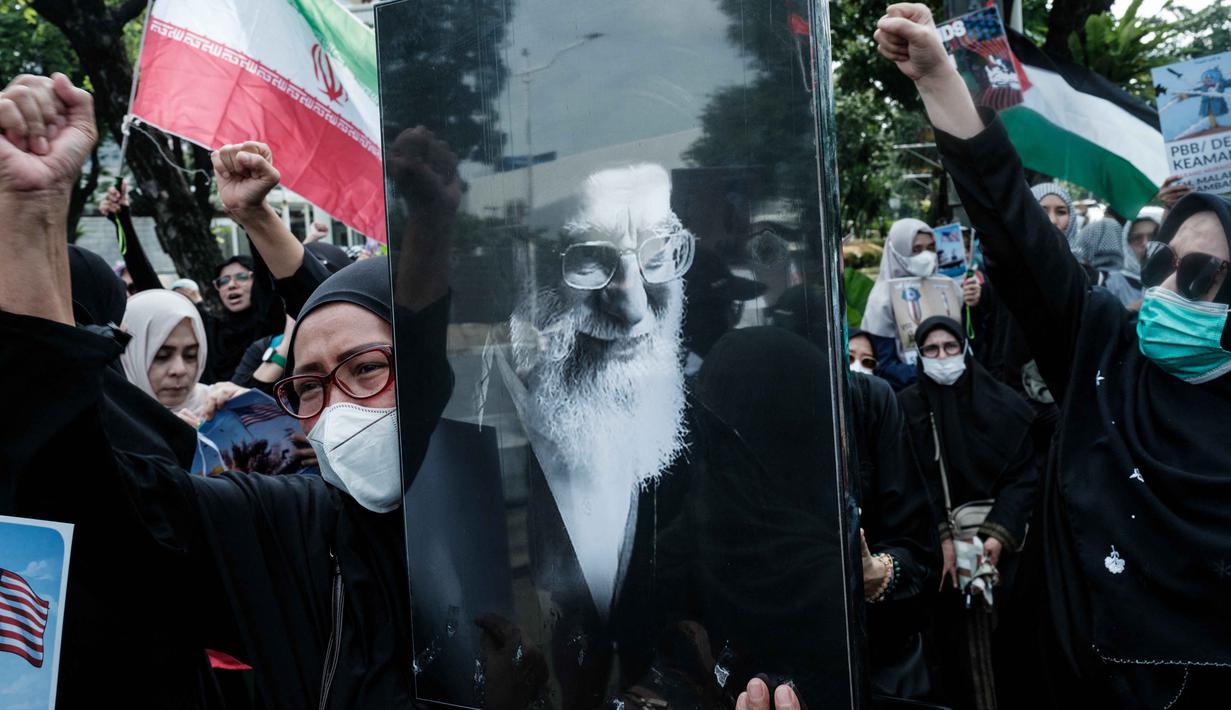 Dalam aksinya, massa tindakan serangan militer Amerika Serikat dan Israel terhadap kedaulatan nasional dan integritas teritorial Iran yang menyebabkan gugurnya Pemimpin Tertinggi Revolusi Islam Iran, Ayatullah Sayyid Ali Khamenei. Tampak dalam foto, seorang pengunjuk rasa memegang potret pemimpin tertinggi Iran, Ayatollah Ali Khamenei, saat berunjuk rasa menentang serangan gabungan Amerika Serikat (AS)-Israel terhadap Iran, di depan Kedutaan Besar Amerika Serikat di Jakarta pada Senin 9 Maret 2026. (YASUYOSHI CHIBA/AFP)