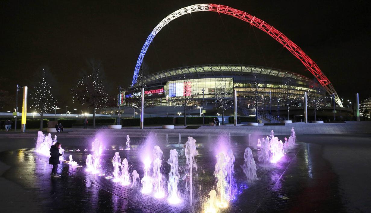 Sebagai bentuk tanda belasungkawa, jelang laga persahabatan Inggris melawan Prancis, Stadion Wembley dihiasi lampu berwarna bendera Prancis, Senin (16/11/2015). (Reuters/Paul Hackett)