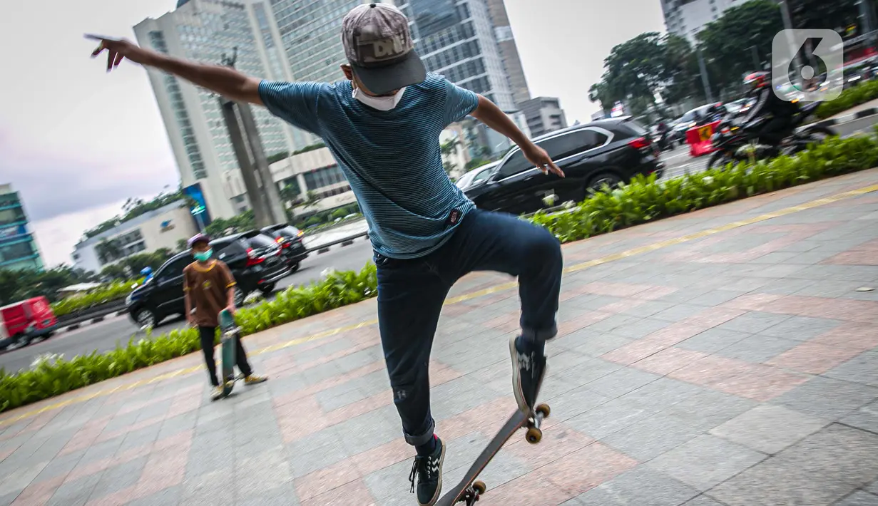 Aksi warga saat bermain skateboard di trotoar Jalan Sudirman-Thamrin, Jakarta, Jumat (5/3/2021). Izin penggunaan trotoar sebagai tempat bermain skateboard keluar usai Gubernur DKI Jakarta Anies Baswedan bertemu dengan salah satu skateboarder Jakarta. (Liputan6.com/Faizal Fanani)
