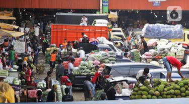 Aktivitas bongkar muat sayur dan buah-buahan di Pasar Induk Kramat Jati, Jakarta Timur, Minggu (12/4/2020). Kegiatan di pasar tersebut berjalan normal selama pandemi COVID-19, namun penjual dan pekerja masih terlihat belum mengenakan masker. (Liputan6.com/Johan Tallo)