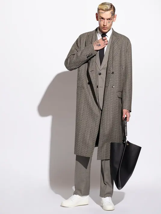 Untuk outfit musim dingin, padukan shirt, suit, dengan longcoat warna coklat. Lengkapi penampilanmu dengan sneaker putih dan totebag hitam (FOTO: doc. Valentino).