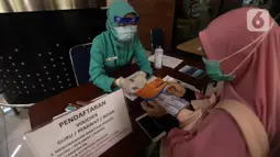 Calon penumpang melakukan pendaftaran untuk mendapatkan voucher tiket kereta api (KA) jarak jauh secara gratis di Stasiun Gambir, Jakarta, Sabtu (7/11/2020). Pembagian voucher dilakukan dalam rangka menyambut Hari Pahlawan pada 10 November. (merdeka.com/Imam Buhori)