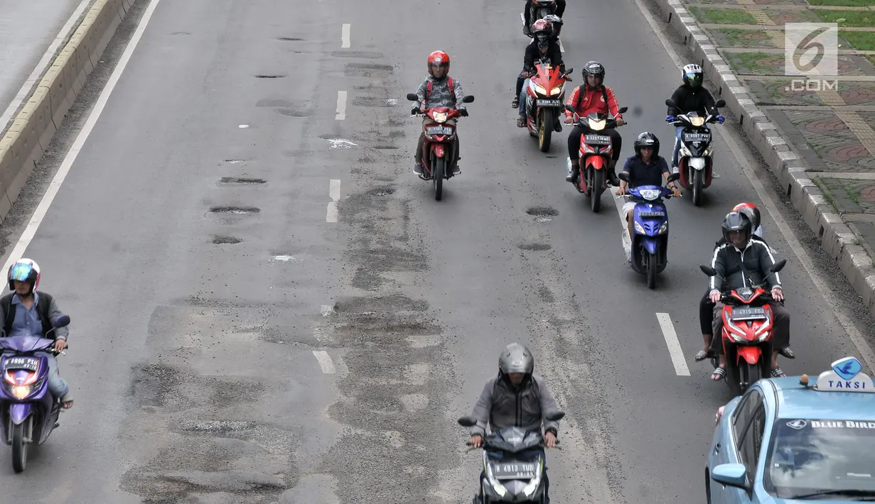 Kendaraan melintasi jalan berlubang di kawasan Gunung Sahari, Jakarta, Selasa (29/1). Sedikitnya terdapat 8 titik jalan rusak dan berlubang di sepanjang Jalan Gunung Sahari berdiameter hingga 10 cm dengan kedalaman 10 cm. (Merdeka.com/Iqbal S. Nugroho)
