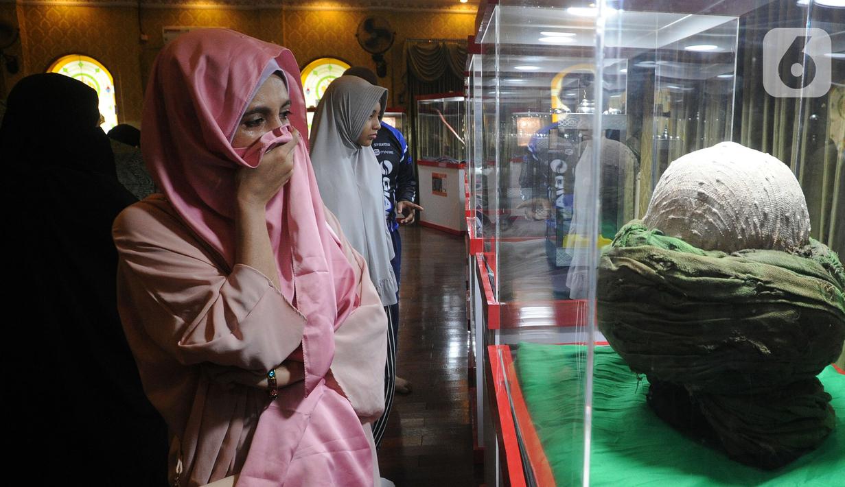 Pengunjung menangis melihat serban Nabi Muhammad SAW saat Pameran Artefak Rasulullah dan Sahabat Nabi di Padepokan Welas Asih, Parung, Kabupaten Bogor, Jawa Barat, Minggu  (26/7/2020). Sebanyak 20 benda peninggalan Nabi Muhammad dan sahabatnya dipamerkan dalam acara ini. (merdeka.com/Arie Basuki)