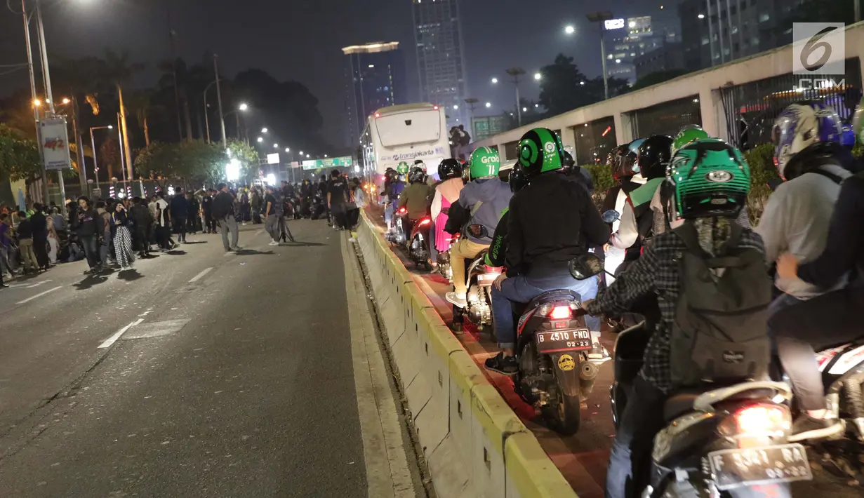Ratusan motor melintas di jalur Transjakarta di sebagian ruas Jalan Gatot Subroto depan Gedung MPR/DPR/DPD RI, Jakarta, Kamis (19/9/2019). Sebagian ruas Jalan Gatot Subroto depan Gedung Parlemen ditutup karena ada aksi mahasiswa menolak revisi RKUHP-UU KPK. (Liputan6.com/Helmi Fithriansyah)