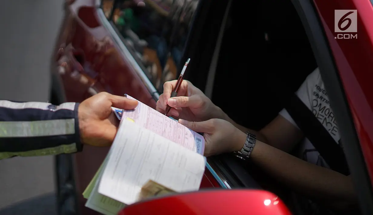 Polisi memberikan surat tilang kepada mobil berplat nomor genap di persimpangan Jalan Dharmawangsa X dan Jalan Fatmawati, Jakarta, Senin (9/9/2019). Perluasan wilayah ganjil genap berlaku mulai hari ini dan terbagi di beberapa titik, salah satunya Jakarta Selatan. (Liputan6.com/Immanuel Antonius)