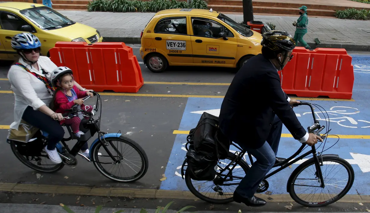 Dua orang pengguna sepeda melintas di persimpangan lampu merah selama "No Car Day" di Bogota, Kolombia (4/2/2016). Selama " No Car Day" Jalur ini juga dapat dilalui para pengguna sepatu roda dan skateboard. (REUTERS/John Vizcaino)