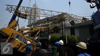 Pekerja mengevakuasi crane yang jatuh di Jalan Kyai Maja, Jakarta Selatan, Kamis (15/10/2015). Alat besar yang tengah melakukan proyek ‎jalan layang ini menimpa salah satu rumah warga yang berada di sisi kanan jalan. (Liputan6.com/Helmi Afandi)