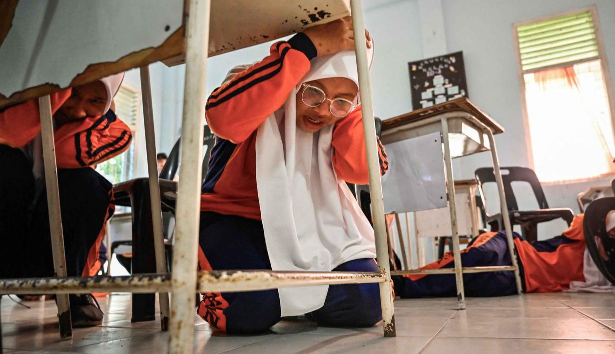 Sejumlah siswa Sekolah Menengah Atas (SMA) mengikuti simulasi gempa bumi dan tsunami untuk memperingati Hari Kesadaran Tsunami Sedunia di Lhoknga, Provinsi Aceh, pada Rabu 5 November 2025. Bertepatan dengan peringatan Hari Kesadaran Tsunami Sedunia setiap tanggal 5 November, siswa salah satu SMA di Lhoknga, Provinsi Aceh, menggelar simulasi mitigasi bencana alam, seperti gempa bumi dan tsunami. (CHAIDEER MAHYUDDIN/AFP)