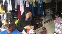 Seorang penjual seragam sekolah di pasar Bambaru, Palu Barat. Aktifitas penjualan di pasar tersebut masih lesu meski menjelang tahun ajaran baru akibat pandemi Covid-19, Kamis (9/7/2020). (Foto: Liputan6.com/ Heri Susanto).