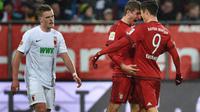 Robert Lewandowski dan Thomas Muller merayakan gol Bayern Munchen ke gawang Augsburg pada laga Bundesliga di WWK Arena, Augsburg, Minggu (14/2/2016) malam WIB. (AFP/Christoph Stache)
