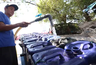 Pedagang mengisi jeriken dengan air bersih untuk segera didistribusikan kepada pelanggan di Kawasan Muara Angke, Jakarta, Kamis (28/5/2026). (Kapanlagi.com/Budy Santoso)