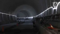 Pekerja menyelesaikan pengerjaan proyek Tunnel 1 Halim Kereta Cepat Jakarta-Bandung di Jalan Tol Jakarta-Cikampek KM 5+500, Jakarta, Kamis (27/1/2022). Tunnel 1 merupakan terowongan dua lintasan kereta cepat yang menembus bagian bawah Jalan Tol Jakarta-Cikampek. (Liputan6.com/Herman Zakharia)