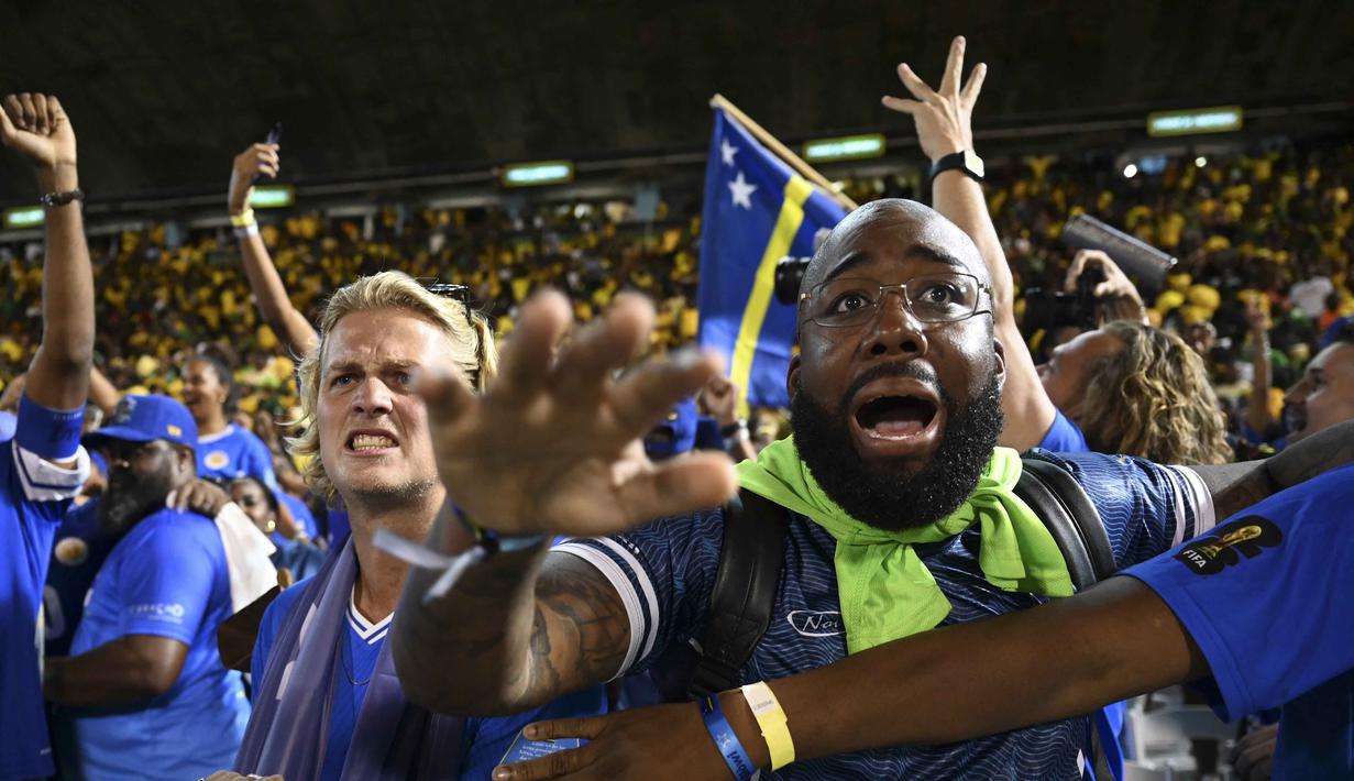 Kepastian tersebut didapat setelah berhasil menahan imbang Jamaika 0-0 pada laga terakhir Grup B Kualifikasi Piala Dunia 2026 zona CONCACAF di Independence Park Stadium, Jamaika, Rabu (19/11/2025) WIB. Tampak dalam foto, suporter Timnas Curacao merayakan hasil imbang melawan Jamaika pada Grup B Kualifikasi Piala Dunia 2026 zona CONCACAF di Independence Park Stadium, Jamaika pada 18 November 2025. (Ricardo MAKYN/AFP)