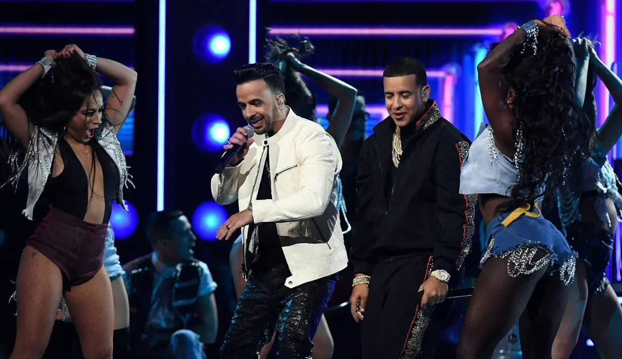 Luis Fonsi dan Daddy Yankee ditemani penari wanita seksi membawakan Despacito di panggung ajang ajang musik bergengsi Grammy Awards 2018 di New York, Minggu (28/1). Despacito sendiri meraih tiga nominasi dalam Grammy Awards 2018.  (Timothy A. CLARY/AFP)