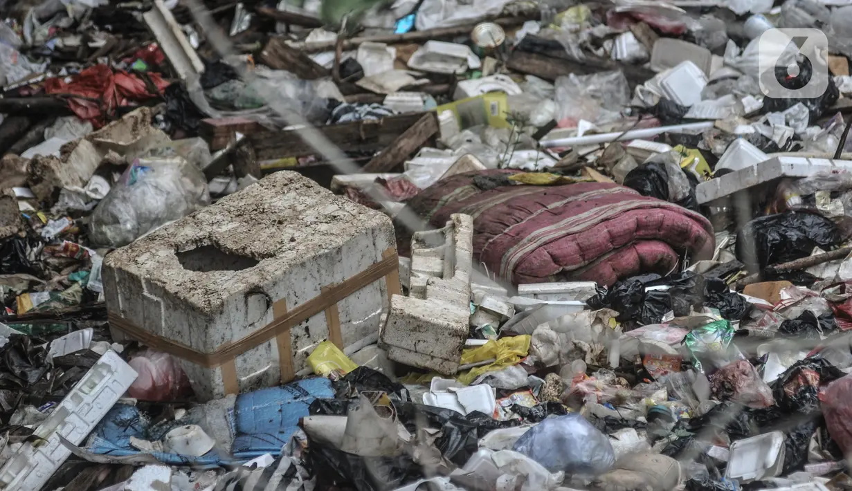 Kondisi tumpukan sampah yang memenuhi aliran Kali Baru, Jalan Raya Bogor, Cimanggis, Depok, Jawa Barat, Minggu (24/1/2021).  Menumpuknya sampah di kawasan perbatasan antara Jakarta dan Depok itu juga diperparah dengan kondisi sungai yang menyempit dan mengalami pedangkalan. (merdeka.com/Iqbal S. Nug