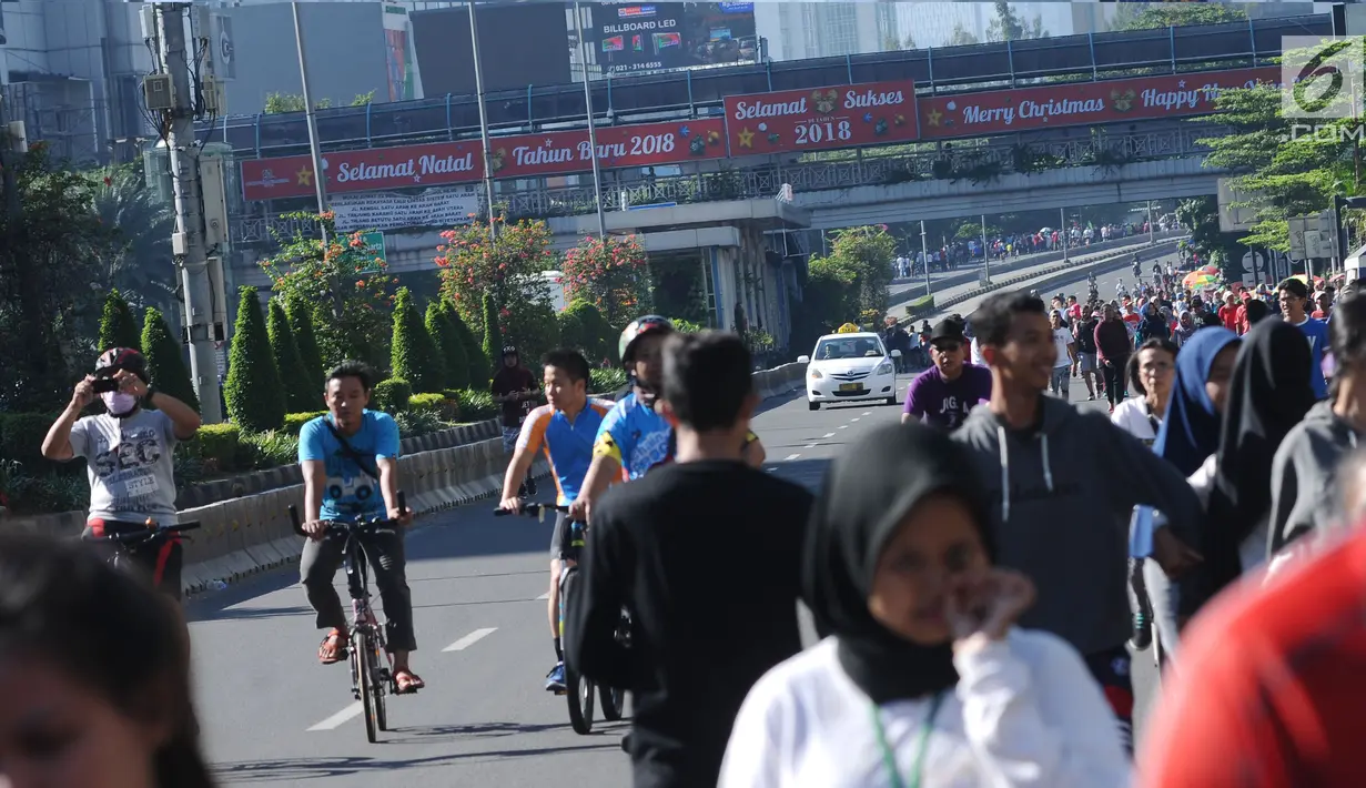 Warga berjalan di kawasan Jalan Jenderal Sudirman, Jakarta, Minggu (31/12). Meski Hari Bebas Kendaraan dipenghujung 2017 ditiadakan, warga tetap memadati kawasan sekitar Jalan Jend Sudirman dan MH Thamtin, Jakarta. (Liputan6.com/Helmi Fithriansyah)
