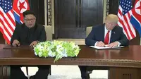 Donald Trump dan Kim Jong-un menandatangani perjanjian di Singapura. (AP/Evan Vucci)
