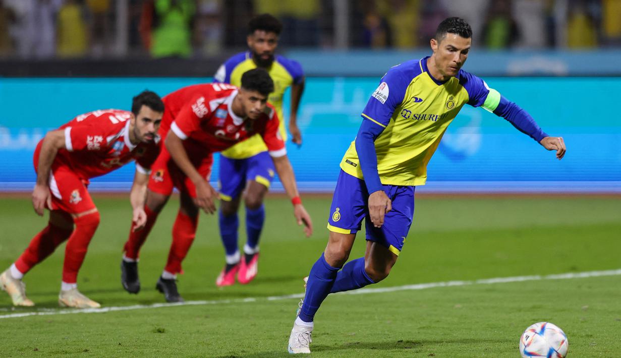 Pemain Al Nassr, Cristiano Ronaldo menendang bola dari titik penalti ke gawang Al Wehda yang membuahkan gol dalam pertandingan lanjutan pekan ke-16 Liga Arab Saudi 2022/2023 yang berlangsung di King Abdulaziz Sports City Stadium, Jumat (10/2/2023) WIB. empat golnya ke gawang Al Wehda memastikan Ronaldo telah mencapai 503 gol di liga sepanjang karier profesionalnya. (AFP)