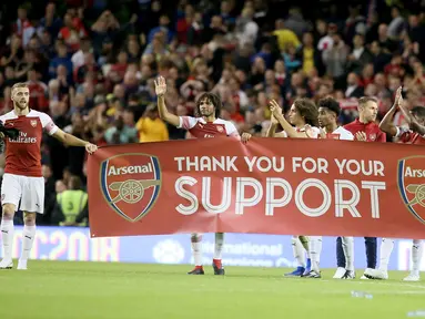 Para pemain Arsenal membawa spanduk menyapa suporter usai pertandingan melawan Chelsea pada  International Champions Cup (ICC) di Stadion Aviva di Dublin (1/8). Arsenal menang atas Chelsea lewat adu penalti 6-5. (AFP Photo/Paul Faith)