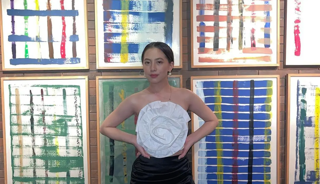 Zara tampil chic dengan atasan putih dengan attachment bunga yang besar, dipadu rok kerut berwarna hitam. [Foto: Instagram/zaraadhsty]