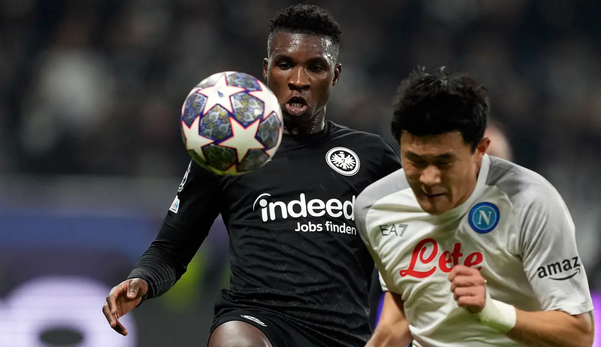 Pemain Eintracht Frankfurt Aurelio Buta (kiri) berduel memperebutkan bola dengan pemain Napoli Kim Min-jae pada pertandingan sepak bola babak 16 besar Liga Champions di Deutsche Bank Arena, Frankfurt, Jerman, 21 Februari 2023. Napoli mengalahkan Eintracht Frankfurt dengan skor 2-0. (AP Photo/Michael Probst)