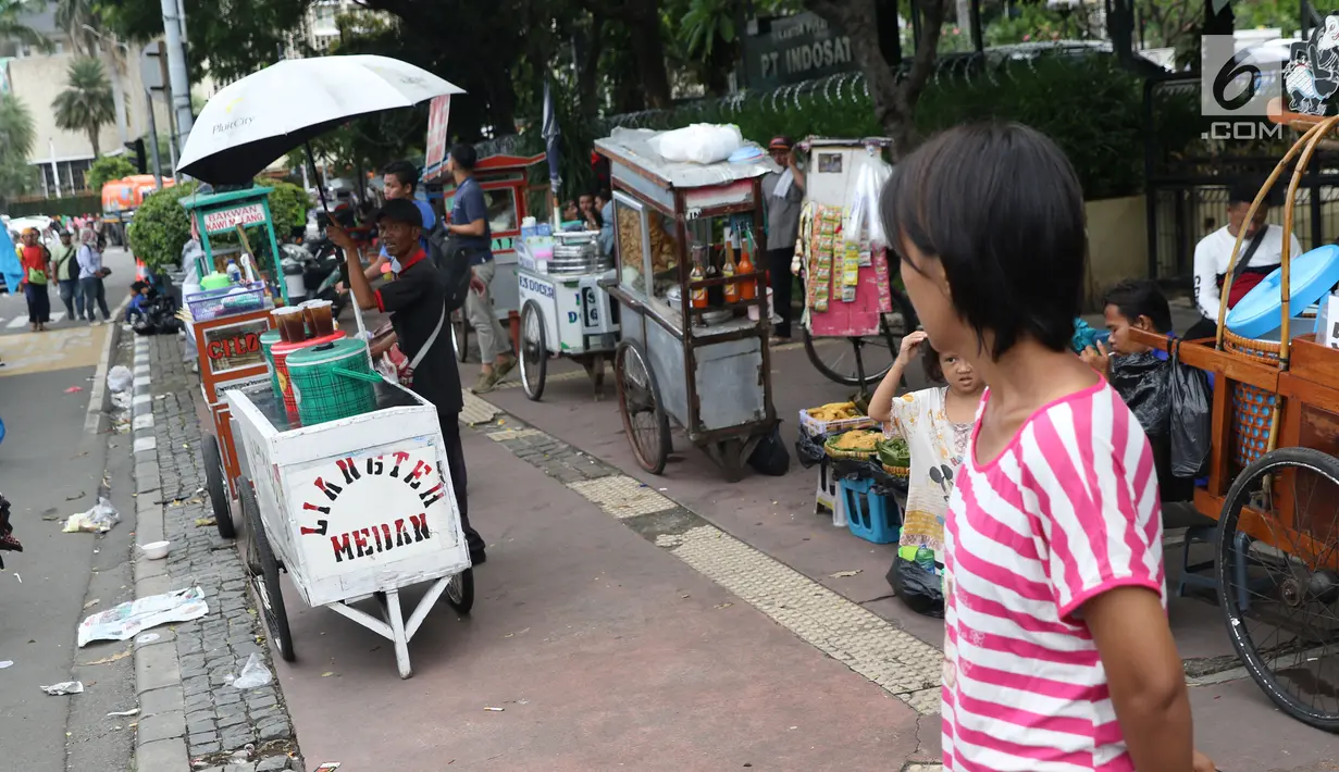 Pedagang kaki lima menjajakan makanan dan minuman di sisi jalan sekitar kawasan Patung Kuda Jakarta, Rabu (5/1/2019). Mereka mencoba peruntungan saat para buruh melakukan aksi perayaan Hari Buruh International atau May Day. (Liputan6.com/Helmi Fithriansyah)
