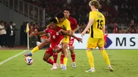 Pemain Timnas Indonesia U-23, Robi Darwis (kiri) berebut bola dengan pemain Malaysia, Muhammad Hakimi dalam laga Grup A Piala AFF U-23 2025 di Stadion Utama Gelora Bung Karno (SUGBK), Senayan, Jakarta, Senin (21/07/2025). (Bola.com/Abdul Aziz)